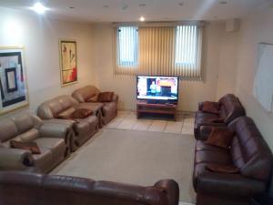 a living room with couches and a flat screen tv at Hotel Capriccio Mauá in Mauá