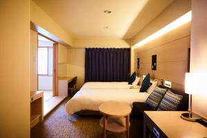 a hotel room with a bed and a couch at Tmark City Hotel Sapporo in Sapporo