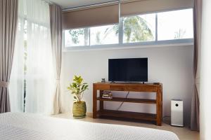 Schlafzimmer mit einem Flachbild-TV auf einem Tisch in der Unterkunft Villa Verde Ko Phangan in Haad Pleayleam