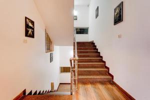 eine Treppe in einem Zimmer mit weißen Wänden und Holzböden in der Unterkunft Super Townhouse Auroville Beach Formerly De Heritage in Kottakupam + 26 Fotos