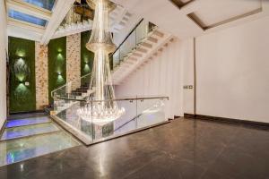 a room with a staircase and a chandelier at Collection O Rudrapur Bus Stand Formerly Corinthian in Rāmpura +22 photos