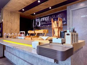 a bakery with a counter with food on it at Ibis Budget Marseille Vitrolles in Vitrolles