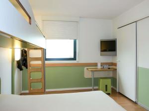 ein Schlafzimmer mit Bett, Schreibtisch und Fenster in der Unterkunft ibis budget Castelnaudary - A61 in Castelnaudary