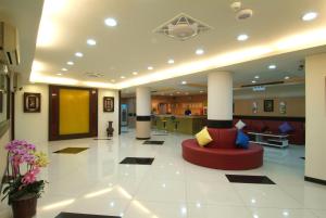 un vestíbulo con un sofá rojo en el medio de un edificio en Puti Commercial Hotel en Longtan