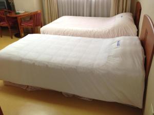 Postel nebo postele na pokoji v ubytování Busan Central Hotel
