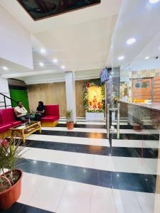 un hall d'entrée avec deux personnes assises sur des chaises rouges dans l'établissement Hotel rajlaxmi executive, à Aurangabad