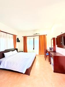 een slaapkamer met een groot bed en een bureau bij Vang Vieng Ruby Villa Hotel in Vang Vieng