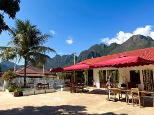 een restaurant met tafels en stoelen en bergen op de achtergrond bij Vang Vieng Ruby Villa Hotel in Vang Vieng