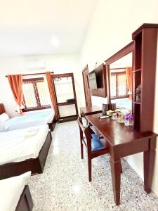 een kamer met een bureau, een bed en een tafel bij Vang Vieng Ruby Villa Hotel in Vang Vieng +48 foto's