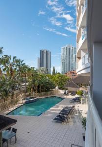 a swimming pool with lounge chairs and a building at Broadbeach Savannah Resort in Gold Coast