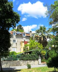 a building with a fence and trees in front of it at Villa Šoulavy in Kaštela