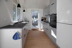 een keuken met witte apparatuur en een houten vloer bij 10070-Rorvig-Kirkestien-25 in Rørvig