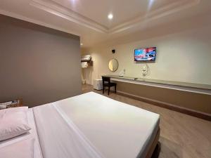 een hotelkamer met een bed, een wastafel en een spiegel bij Rattana View in Phitsanulok