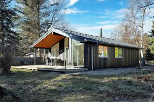 een klein huisje met een veranda en glas bij 10070-Rorvig-Kirkestien-25 in Rørvig