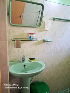 une salle de bains avec un lavabo vert et un miroir dans l'établissement Mango Villa Hiriketiya, à Hiriketiya