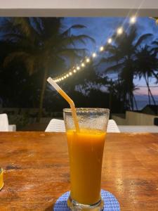 een glas sinaasappelsap op een tafel bij Rella Dream in Matara +32 foto's