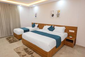 een slaapkamer met 2 bedden met blauwe en witte lakens bij Munderi Green Mounts - Premium Pool Stay Near Kalpetta, Wayanad in Kalpatta +25 foto's