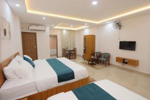 a hotel room with two beds and a television at Munderi Green Mounts - Family Rooms with Pool, Wayanad, Kalpetta in Kalpetta