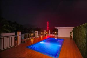 a swimming pool on the deck of a house at night at Munderi Green Mounts - Family Rooms with Pool, Wayanad, Kalpetta in Kalpetta +45 photos