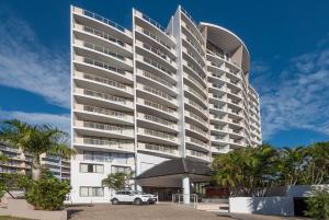 a building with a car parked in front of it at Broadbeach Savannah Resort in Gold Coast