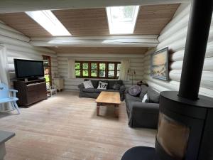 een woonkamer met een bank en een tv in een huis bij 12254-Nykobing-Sj-Peter-Andersensvej-5 in Tjørneholm