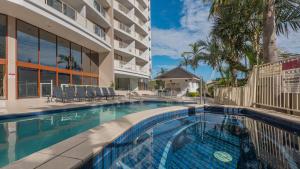 a swimming pool in front of a building at Broadbeach Savannah Resort in Gold Coast