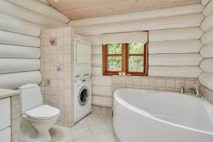 een badkamer met een bad, een toilet en een wasmachine bij 12254-Nykobing-Sj-Peter-Andersensvej-5 in Tjørneholm +20 foto's