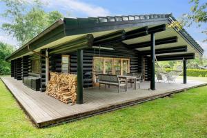een blokhut met een tafel en stoelen op een terras bij 12254-Nykobing-Sj-Peter-Andersensvej-5 in Tjørneholm