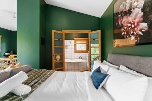a bedroom with a white bed and a green wall at 2BR plus Studio Pool & Spa Sleeps 8 in Daylesford