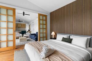 a bedroom with a large bed and a living room at 2BR plus Studio Pool & Spa Sleeps 8 in Daylesford