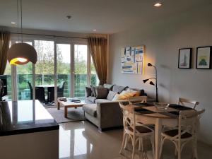 Una sala de estar con un sofá y una mesa con sillas. en Baan View Viman Room 301, en Hua Hin