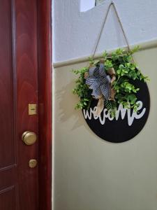 a sign that says welcome hanging on a door at Twins Apartments 2 in Serres