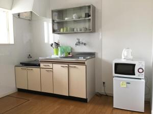 a kitchen with a sink and a microwave at La Curación in Naoshima