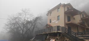 een gebouw op een heuvel in de mist bij Suncani Breg in Crni Vrh
