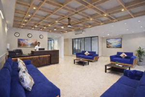 a man standing in a lobby with blue couches at Hotel Apple Wood Delhi Airport With Free Airport Drop in New Delhi