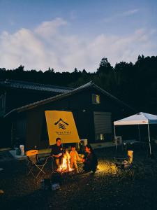 een groep mensen die rond een kampvuur zitten bij Three Field Tamba-Sasayama in Sasayama +25 foto's