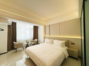 万象四季Four Seasons Hotel的卧室里有一张白色的大床和一张桌子