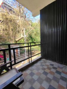 Zimmer mit Balkon und Blick auf einen Baum in der Unterkunft Havemore home stay in Solan