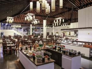 een restaurant met een buffet met tafels en stoelen bij Novotel Goa Dona Sylvia Resort in Cavelossim