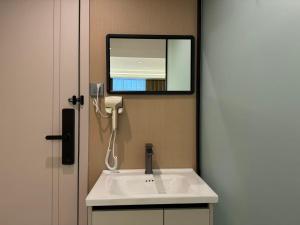 万象四季Four Seasons Hotel的浴室里有白色洗手池和镜子