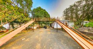 a large wooden bridge in a park with trees at Tejas Gir Villas in Sasan Gir +3 photos