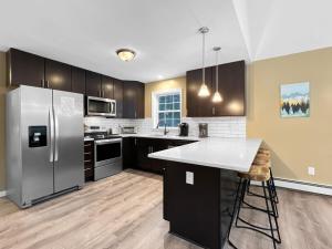 una cucina con frigorifero in acciaio inossidabile e bancone di The Mendon House Brought to you by GetAway Vacations a Killington