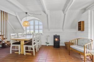 una sala da pranzo con tavolo e stufa a legna di LF14258-Fur-Marehalmvej-8 a Fur