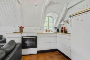 una cucina con piano cottura e un divano in camera di LF14258-Fur-Marehalmvej-8 a Fur Altre 16 foto
