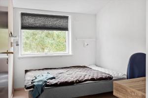 een kleine slaapkamer met een bed en een raam bij LF10320-Hurup-Thy-Nattergalevej-2-B in Sønder Ydby