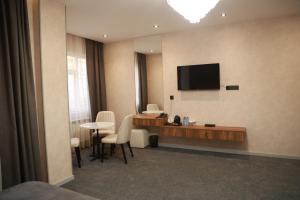 een hotelkamer met een bureau en een televisie aan de muur bij GREEN PARK HOTEl in Baku