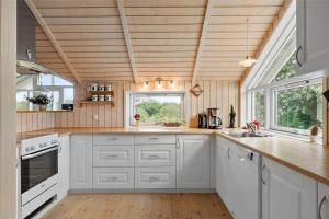 a kitchen with white cabinets and a wooden ceiling at LF21631-Spottrup-Vibevej-3 in Spottrup