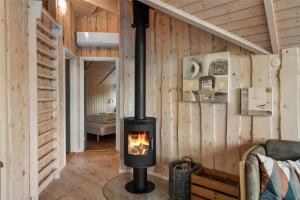 a fireplace in a room with wooden walls at LF21631-Spottrup-Vibevej-3 in Spottrup