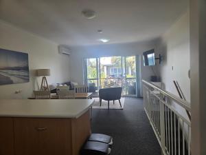ein Wohnzimmer mit einer Küche und ein Wohnzimmer mit einem Tisch in der Unterkunft Waterfront Hideaway with Pool, Spa & BBQ Area jetty available in Mandurah