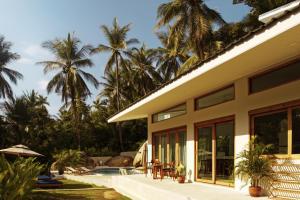 ein Haus mit Pool und Palmen im Hintergrund in der Unterkunft Villa Verde Ko Phangan in Haad Pleayleam